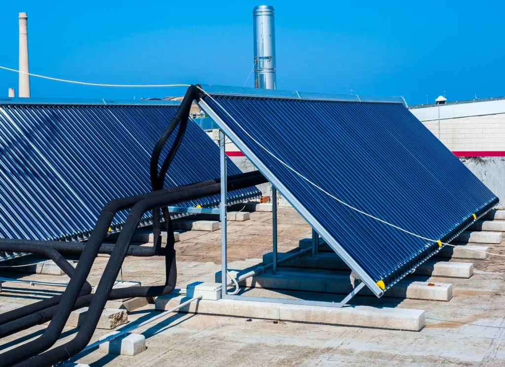 Roof-mounted solar pool heating panels installed above a backyard pool Ground-mounted solar thermal collectors used for pool heating
