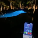 Smartphone controlling lighting and features for a backyard swimming pool at night