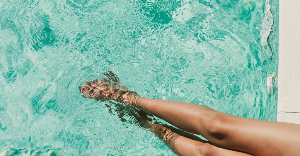 Person swimming in a clear turquoise swimming pool