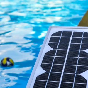 Solar panel placed beside a swimming pool with water in the background