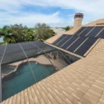 Solar pool heating panels installed beside a residential swimming pool